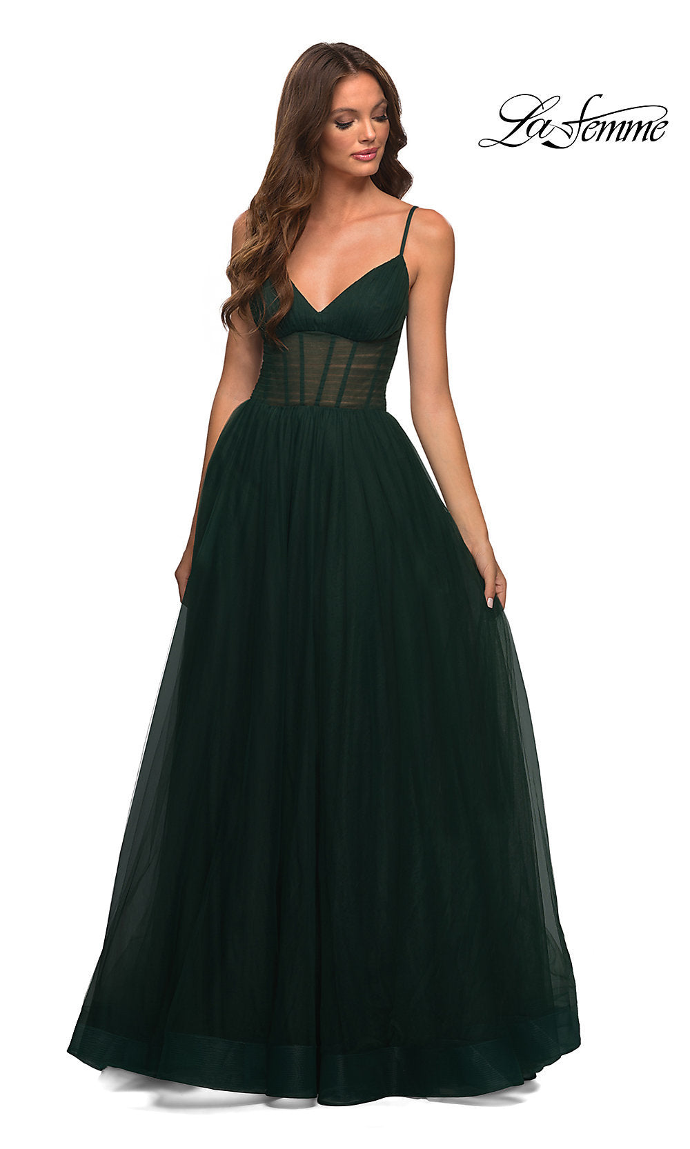 A woman in a Long La Femme Prom Dress with a sheer corset waist and floor-length tulle skirt stands against a white background, with the